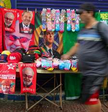 Ambulante com toalhas de Lula e Flávio Bolsonaro a venda na rua Siqueira Campos, em Copacabana, zona sul do Rio de Janeiro. Foto: Pedro Kirilos/Estadão / Estadão